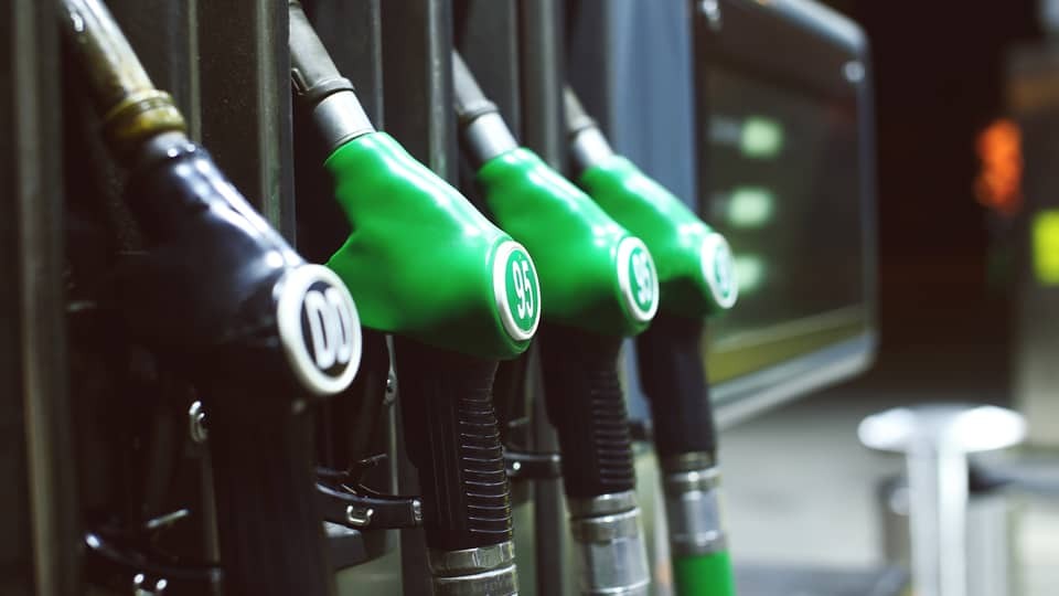 Green and black fuel pistols at a fuel station